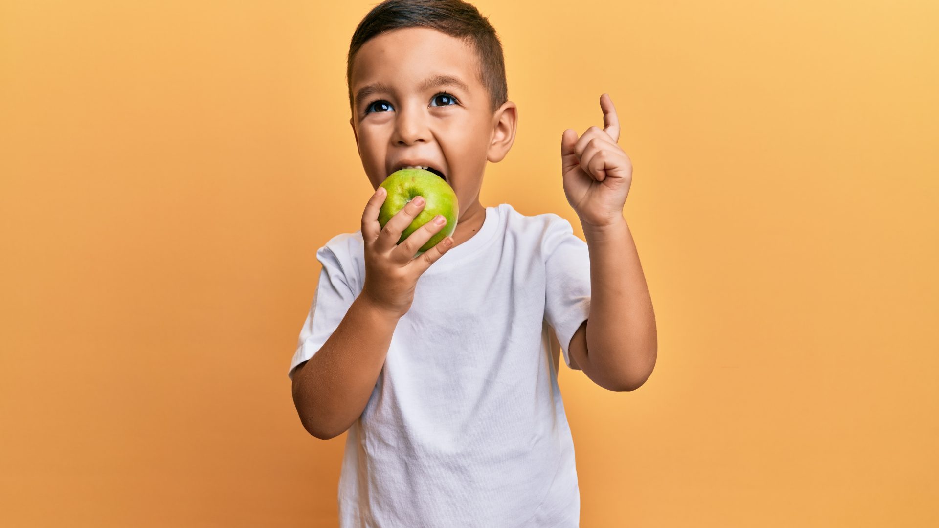 Adorable,Latin,Toddler,Smiling,Happy,Eating,Green,Apple,Looking,To