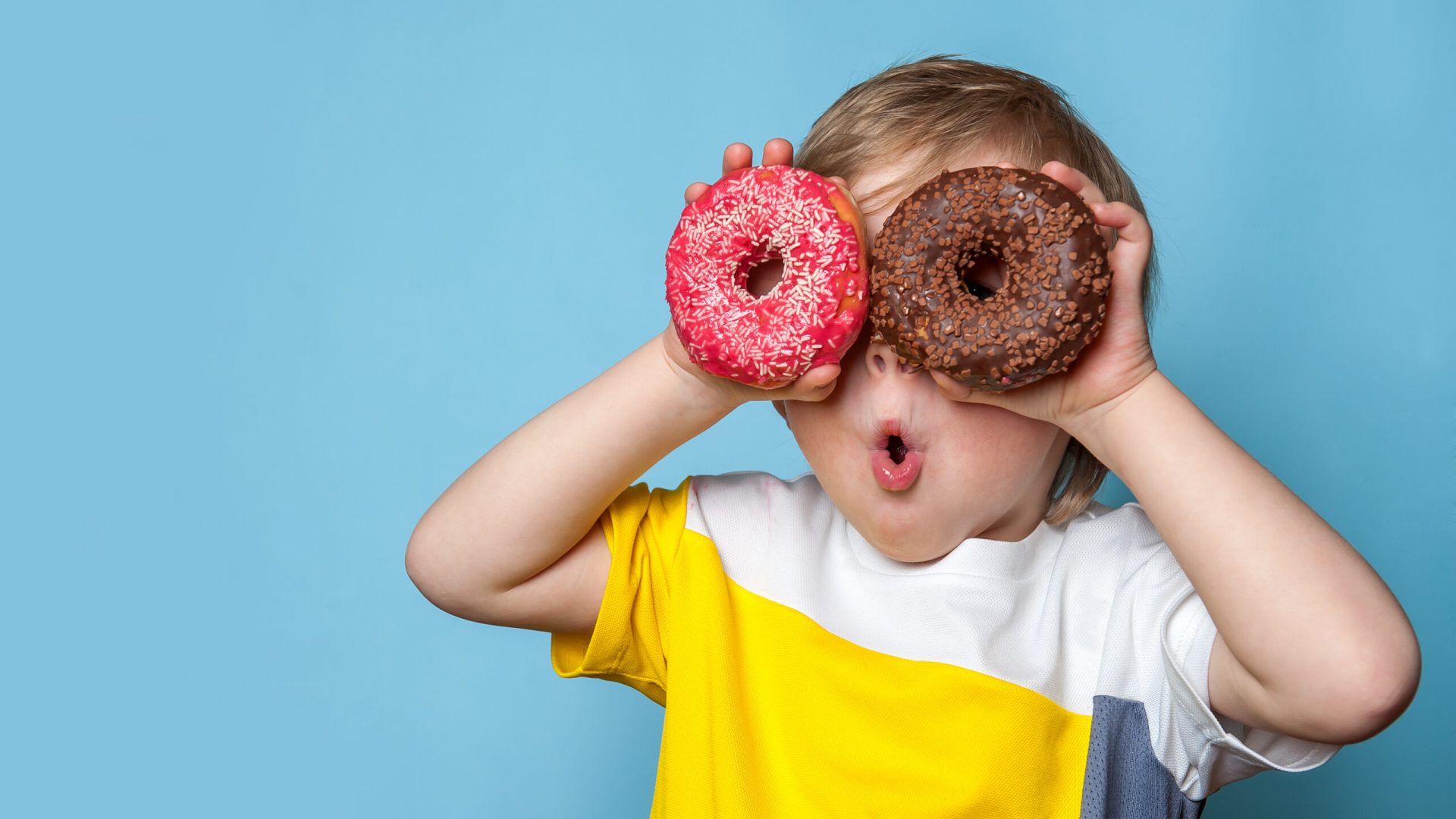 Little,Happy,Cute,Boy,Is,Eating,Donut,On,Blue,Background